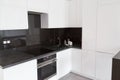 White kitchen with flat facades and black skinali.