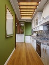 White kitchen furniture in the interior of the kitchen in the Arabian style with green walls and wooden ceiling backlighting Royalty Free Stock Photo