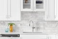 A white kitchen sink detail shot with marble subway tiles. Royalty Free Stock Photo