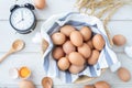 White kitchen table with fresh raw eggs, yellow yolk eggs, white heart shape sign and classic vintage clock. Royalty Free Stock Photo