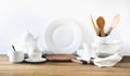 White kitchen utensils, dishware and other different white stuff for serving on white wooden board. Royalty Free Stock Photo