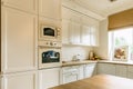 White kitchen wall with microwave and oven. Big window on the right wall Royalty Free Stock Photo