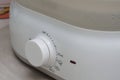 A white kitchen warmer heat heating level adjustment knob close up