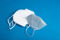 white KN95 mask with antiviral medical mask for protection against coronavirus on blue background