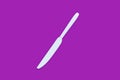 White knife on violet background. Top view