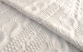 White knitted blanket folded diagonally