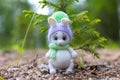 A white knitted bunny is sitting by a green Christmas tree. Royalty Free Stock Photo