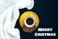 White knitted fabric, gold cup with coffee and yellow plate with flavored cookies on dark black background Royalty Free Stock Photo