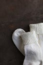 White knitted natural wool socks on a beige and gray table.