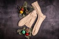 White knitted socks and Christmas decorations on a gray wooden background Royalty Free Stock Photo