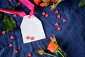 White label with a pink ribbon surrounded by little hearts and an orange rose Royalty Free Stock Photo