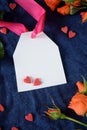 White label with a pink ribbon surrounded by little hearts and orange roses Royalty Free Stock Photo