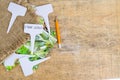 White labels-markers for plants lie on burlap, on wooden background.