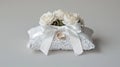 A white lace wedding ring pillow with a satin bow and artificial roses Royalty Free Stock Photo
