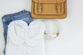 White lace women`s blouse, blue jeans, a brown handbag and a white belt on a white background. Women`s casual outfits. Flat lay, Royalty Free Stock Photo