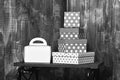 White ladies handbag and pretty sweet presents boxes on black tray on wooden background, copy space.