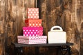 White ladies handbag and pretty sweet presents boxes on black tray on wooden background, copy space.