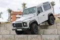 White Land Rover Defender off-road jeep on concrete stairways during an exhibition in a park