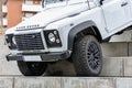 White Land Rover Defender off-road jeep on concrete stairways during an exhibition in a park