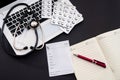 white laptop on which a stethoscope, pills, syringe, thermometer and a side notebook with a pen Royalty Free Stock Photo