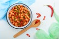 White large beans in sweet and sour tomato sauce in a bowl on a light background. The top view. Vegetarian cuisine. Royalty Free Stock Photo