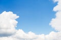 White large fluffy clouds frame a clear blue sky