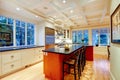 White large luxury kitchen with huge wood island and refrigerator.