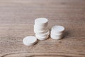 White large pills close up stand in a pile on a wooden background. Vitamins, pharmaceuticals for the treatment of diseases