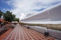 The white large reclining Buddha sculpture outdoor with beautiful sky in Wat Satu