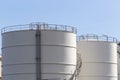 White large storage tanks under a blue sky.