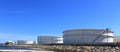 White large storage tanks under a blue sky.