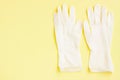 White latex protective gloves on yellow background Royalty Free Stock Photo