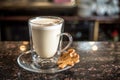 White latte coffee drink with a cookie in a bar