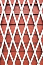 White lattice trellis for flower support on a red wall