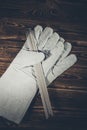 White leather welding glove and welding electrodes on a wooden background. Studio photo in hard light