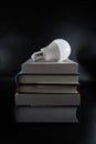 White led light bulb on a pile of books