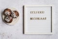 A white letterboard with Gelukkig Nieuwjaar (Dutch for Happy New Year) with oliebollen Royalty Free Stock Photo