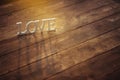 White letters stand on the wooden surface in the warm sun