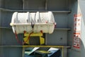 White life raft without hydrostatic release secured in forward station of container ship.