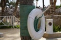 White lifebuoy on a pillar by an outdoor pool