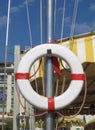 White lifebuoy with ropes are hanging on a mast