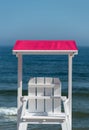 White lifeguard chair visible from the back with a pink visor against the background of a beautiful blue sea and sky on a summer s Royalty Free Stock Photo