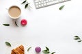 White background with macaroons, cup of coffee and keyboard, top view