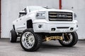 White lifted GMC truck parked outdoors