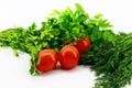 Three small red tomatoes placed with greens on a white background Royalty Free Stock Photo