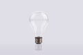 A White light bulb in front of a grey background Royalty Free Stock Photo