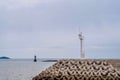 White light and red lighthouse at small seaport Royalty Free Stock Photo