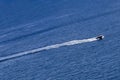 A speedboat at high speed, leaving a trail of foam