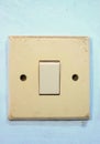 A white light switch attached to the wall is used to turn the lights on and off Royalty Free Stock Photo