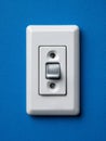 White light switch on blue wall for modern interior design. Royalty Free Stock Photo